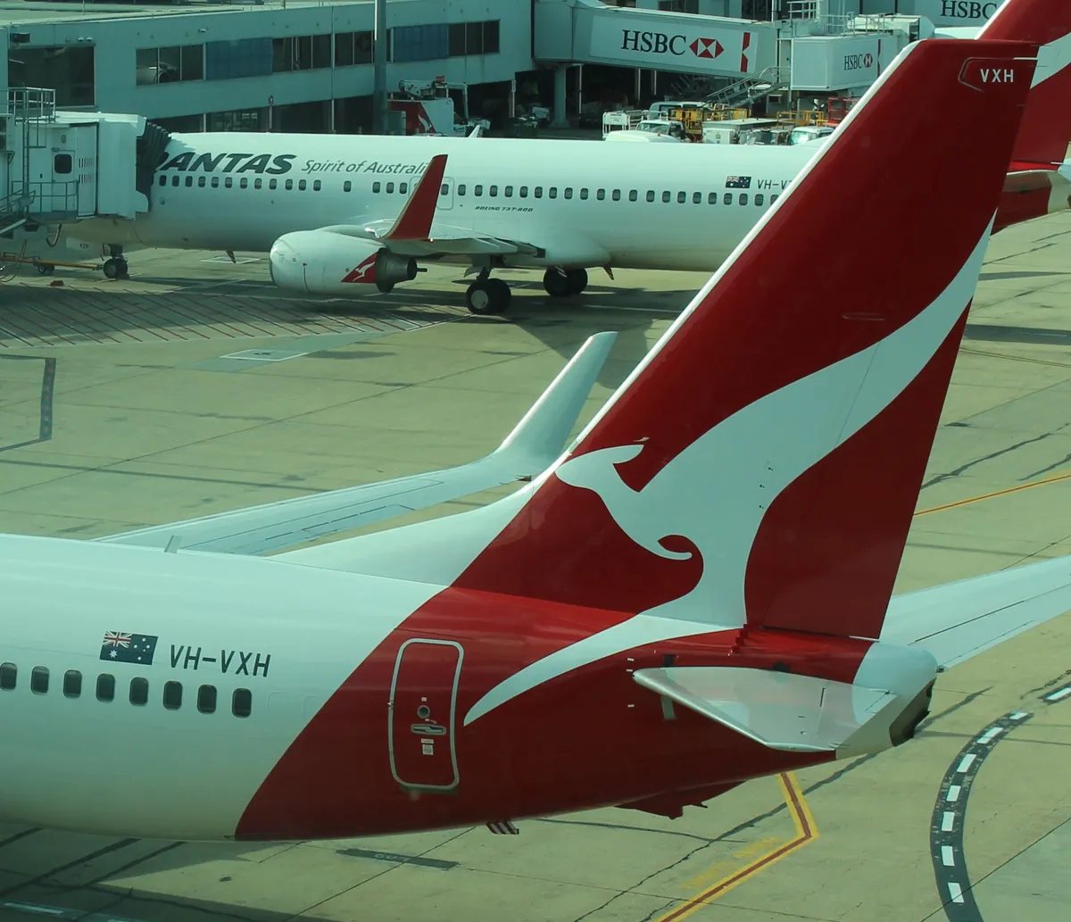 Close-up of a Qantas Boeing 737-800 tail with the registration VH-VXH painted on the fuselage